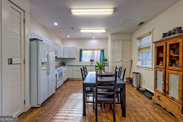 kitchen featuring dark wood-type flooring, white appliances, decorative backsplash, and white cabinets