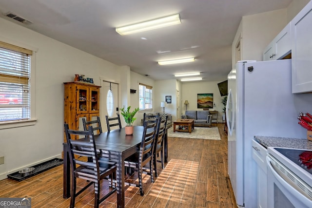 dining space with dark hardwood / wood-style floors