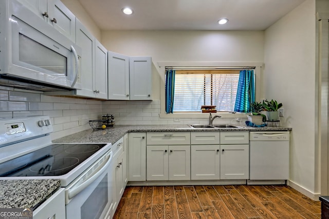 kitchen featuring light stone counters, white appliances, sink, and white cabinets