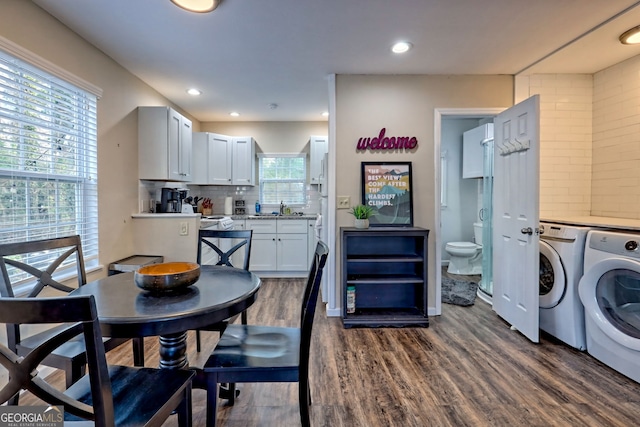 kitchen featuring white cabinetry, separate washer and dryer, sink, decorative backsplash, and dark wood-type flooring