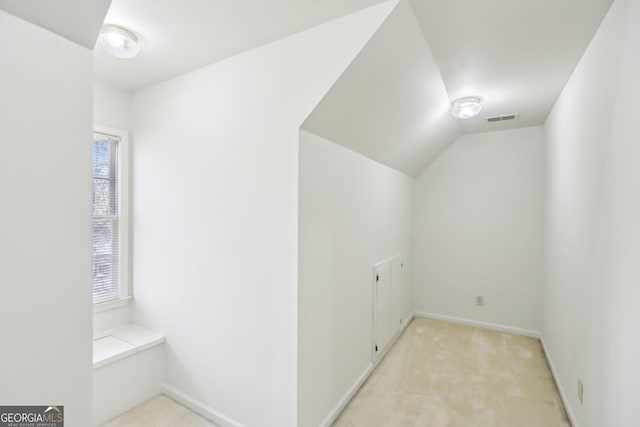 interior space with light carpet and lofted ceiling