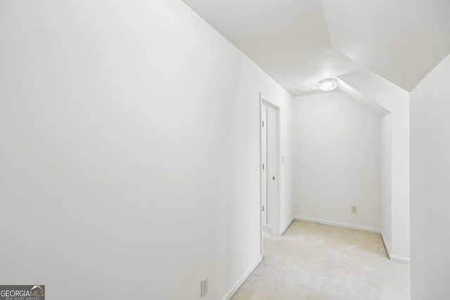 additional living space featuring light colored carpet and lofted ceiling