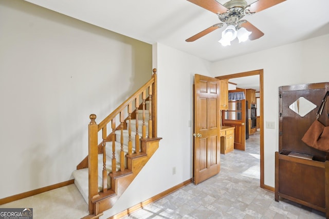 stairs featuring ceiling fan