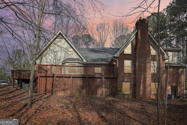 yard at dusk featuring a wooden deck