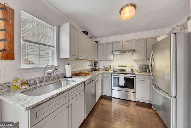 kitchen with sink, crown molding, dark wood-type flooring, stainless steel appliances, and light stone countertops