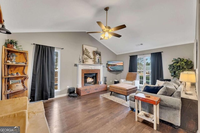 living room with lofted ceiling, hardwood / wood-style flooring, ceiling fan, a fireplace, and ornamental molding