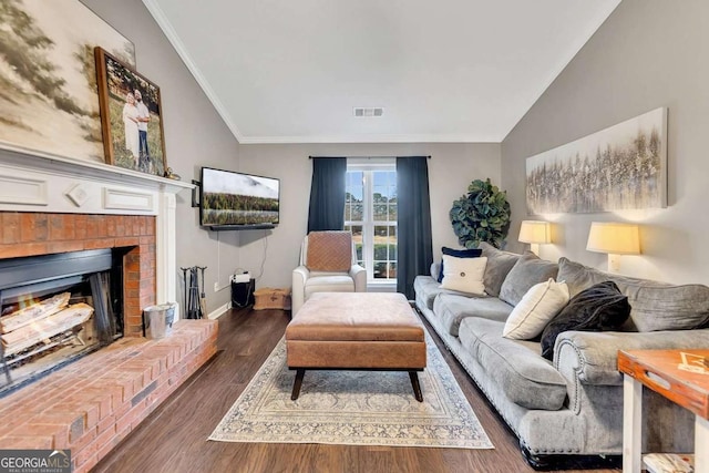 living room with crown molding, a fireplace, dark hardwood / wood-style flooring, and vaulted ceiling