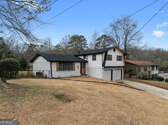 tri-level home featuring a garage and a front lawn