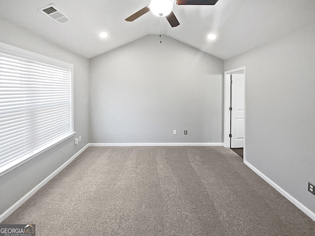 carpeted empty room with vaulted ceiling and ceiling fan