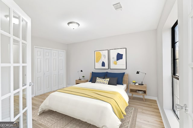 bedroom with light hardwood / wood-style floors and a closet