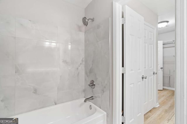 bathroom featuring hardwood / wood-style floors and tiled shower / bath combo