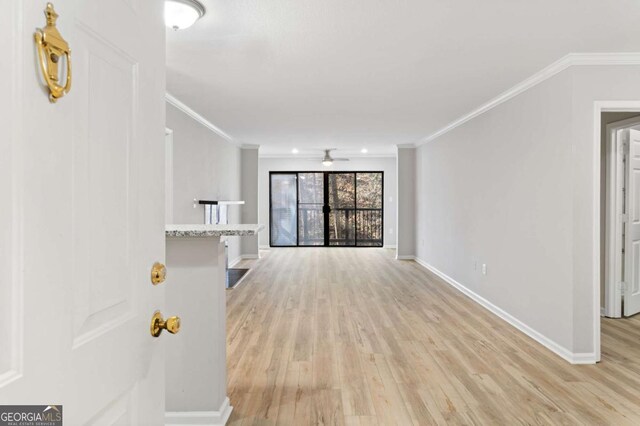 unfurnished living room featuring ornamental molding and light hardwood / wood-style floors