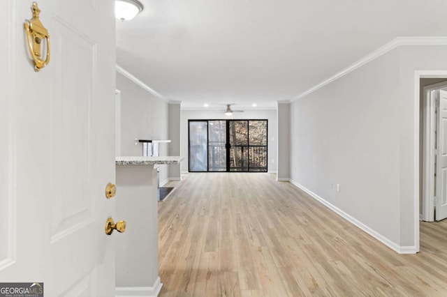 unfurnished living room featuring ornamental molding and light hardwood / wood-style flooring