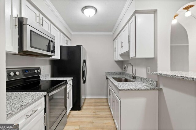 kitchen with white cabinetry, appliances with stainless steel finishes, sink, and ornamental molding