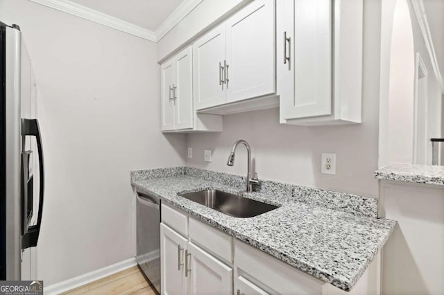 kitchen with sink, white cabinetry, ornamental molding, stainless steel appliances, and light stone countertops