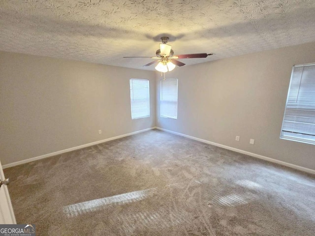 empty room featuring ceiling fan, carpet floors, and a textured ceiling