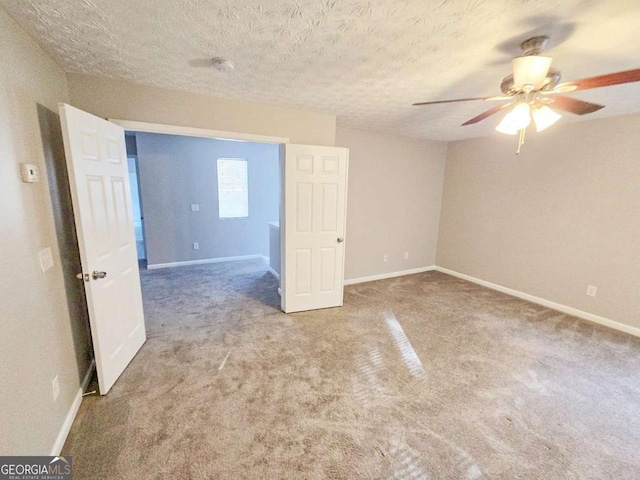 carpeted spare room featuring ceiling fan and a textured ceiling