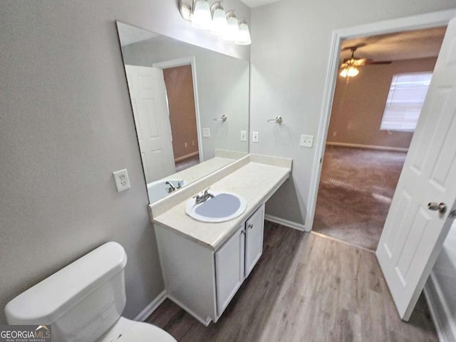 bathroom with vanity, toilet, and hardwood / wood-style floors