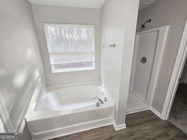 bathroom featuring shower with separate bathtub and hardwood / wood-style floors