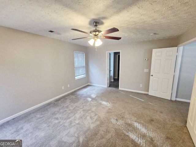 spare room with ceiling fan, carpet flooring, and a textured ceiling