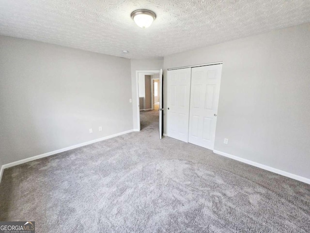 unfurnished bedroom featuring carpet flooring, a closet, and a textured ceiling