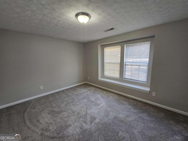 carpeted empty room with a textured ceiling