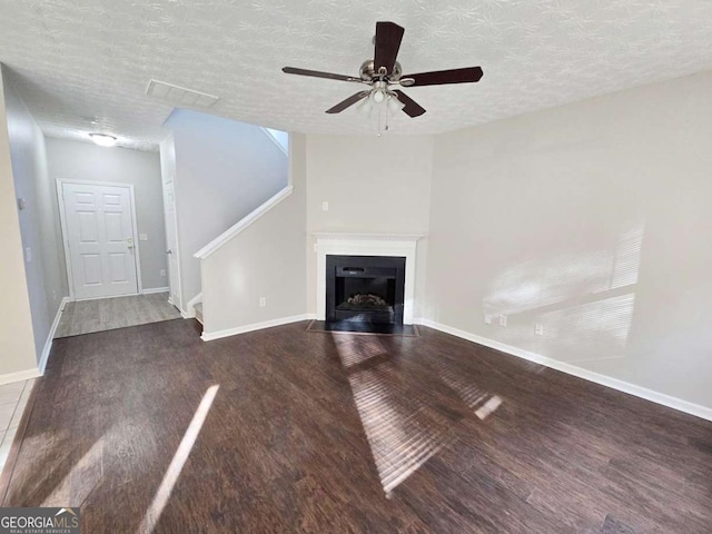 unfurnished living room with hardwood / wood-style flooring, ceiling fan, and a textured ceiling