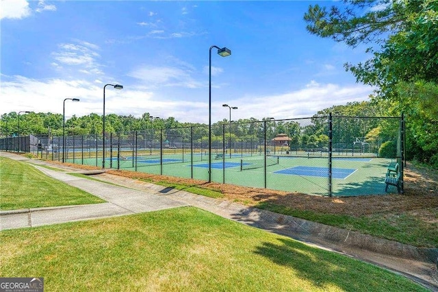 view of tennis court with a lawn