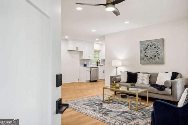 living room with ceiling fan and light hardwood / wood-style floors