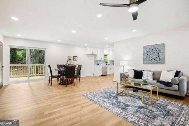 living room featuring ceiling fan and light wood-type flooring