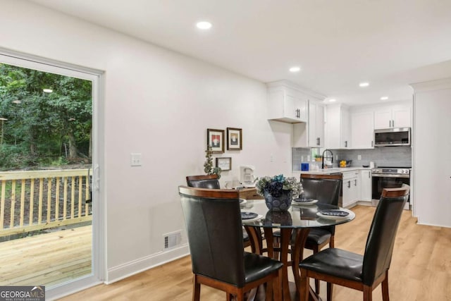 dining room featuring sink and light hardwood / wood-style floors