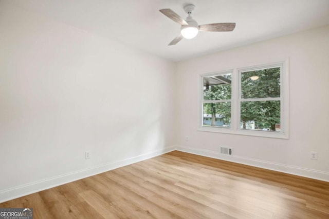 spare room with ceiling fan and light wood-type flooring