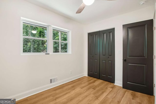 unfurnished bedroom with ceiling fan, light hardwood / wood-style floors, and a closet