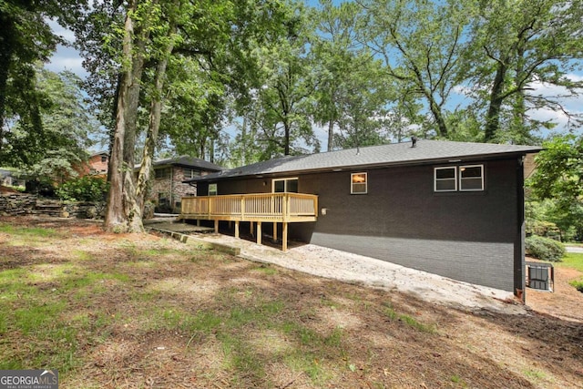 rear view of house featuring a wooden deck