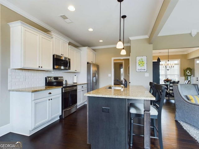 kitchen with stainless steel appliances, white cabinets, and decorative light fixtures