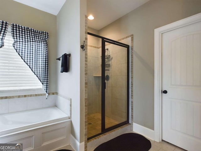 bathroom with shower with separate bathtub and tile patterned floors