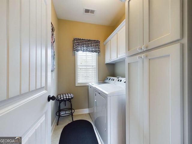 laundry room with cabinets, washing machine and dryer, and light tile patterned floors