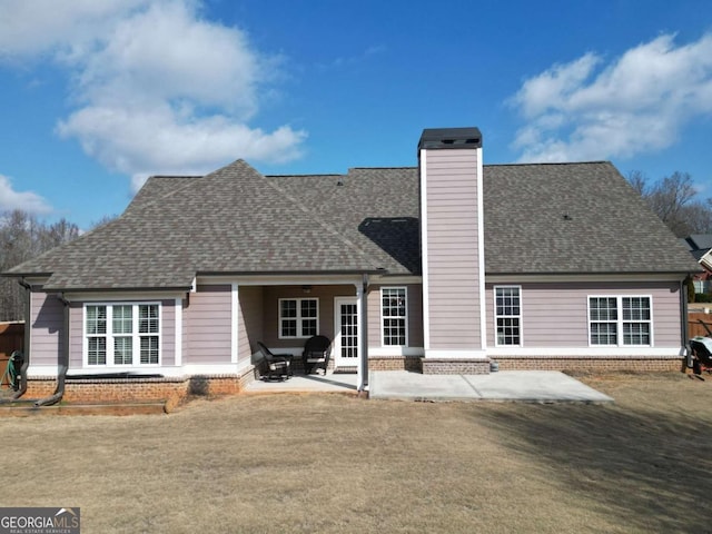 rear view of house with a yard and a patio area