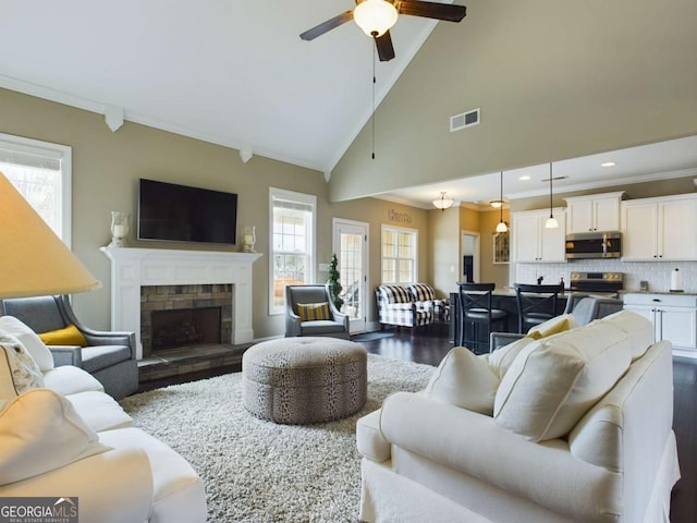 living room featuring a fireplace, ceiling fan, dark hardwood / wood-style flooring, and crown molding