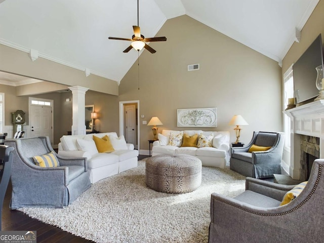 living room with dark wood-type flooring, crown molding, high vaulted ceiling, ceiling fan, and decorative columns