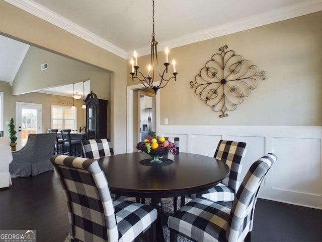 dining space with ornamental molding, dark hardwood / wood-style floors, and a notable chandelier