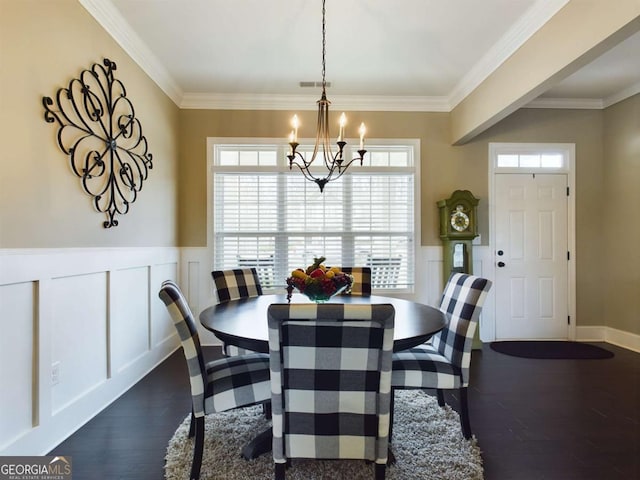 dining area with crown molding, dark wood-type flooring, and a chandelier