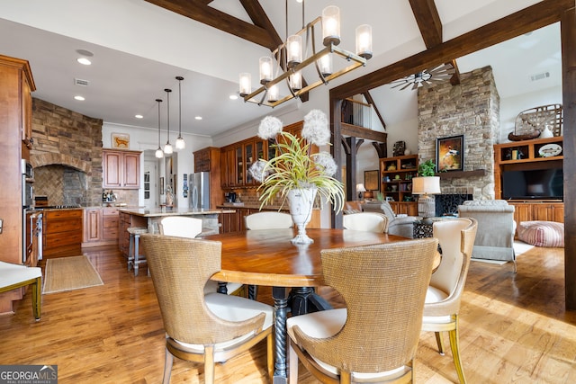 dining area with a fireplace, light hardwood / wood-style floors, and beam ceiling