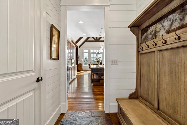 mudroom featuring vaulted ceiling, dark hardwood / wood-style flooring, and wood walls