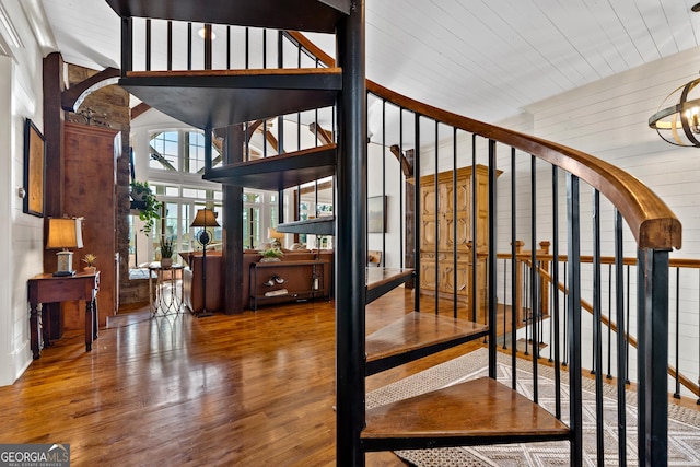 stairs featuring wooden walls and hardwood / wood-style floors