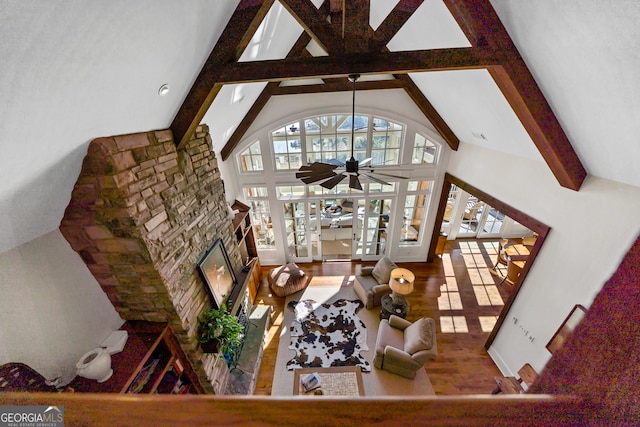 living room with wood-type flooring, high vaulted ceiling, beamed ceiling, ceiling fan, and a fireplace