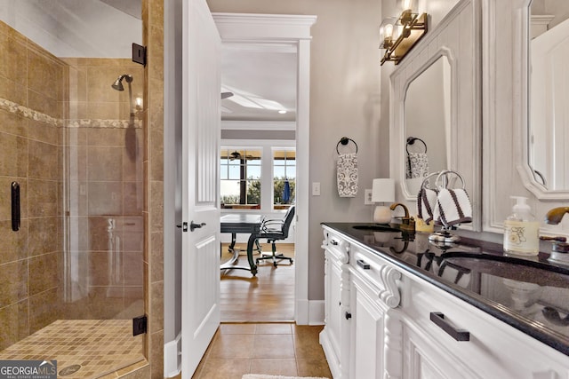 bathroom featuring walk in shower, tile patterned floors, crown molding, and vanity