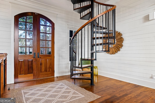 entrance foyer featuring hardwood / wood-style flooring, french doors, and wood walls