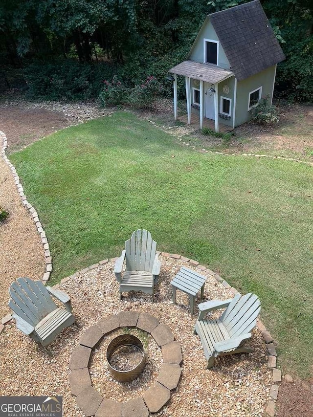 view of yard with an outdoor structure and an outdoor fire pit