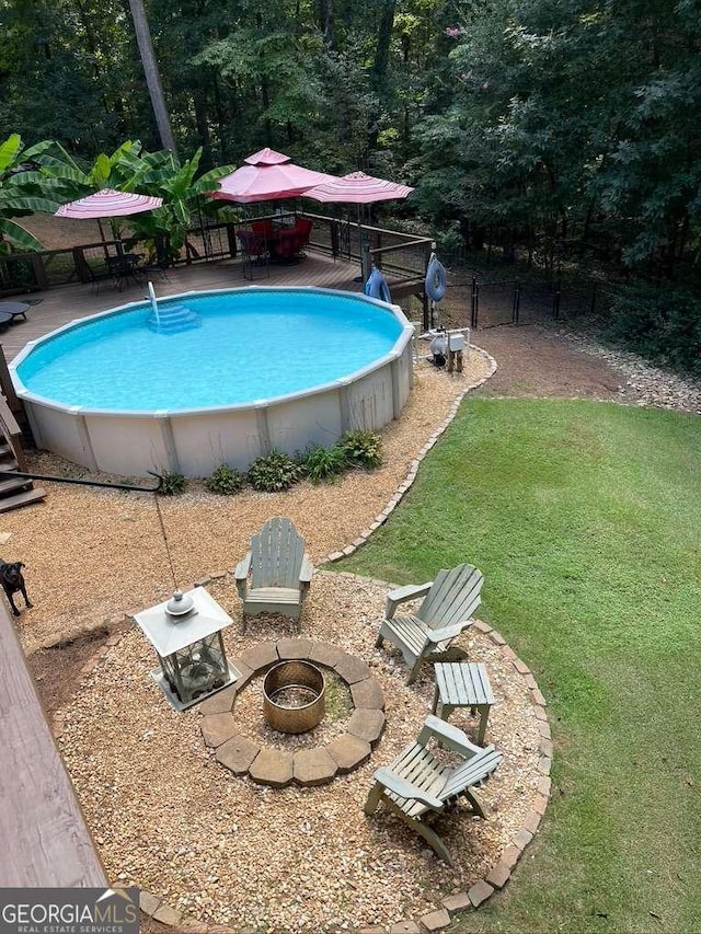 view of swimming pool featuring an outdoor fire pit